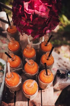 lots of juice bottles on a vintage wooden table. wedding rustic