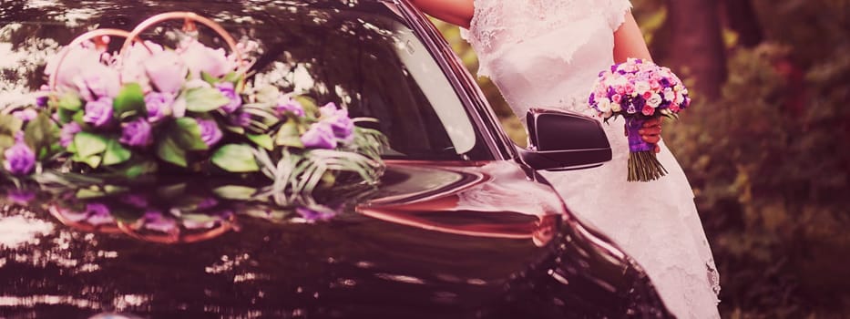 a bride with a bouquet on the background of a decorated wedding car