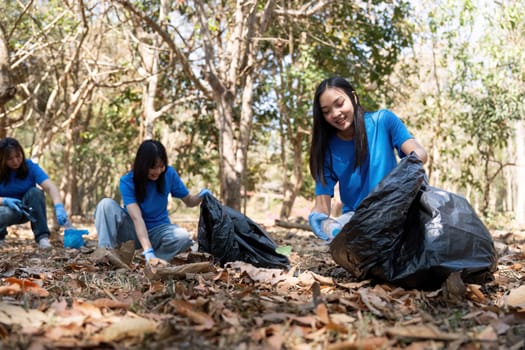 Young people friend volunteer collecting garbage plastic bottles to trash bags. environmental care ecology concept.
