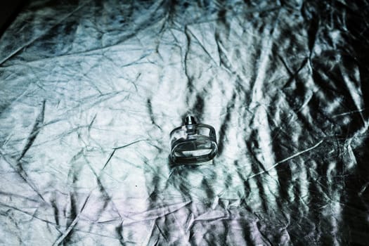 female perfume in beautiful bottle on silver background