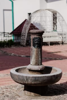 small fountain with head of lion on one european of the streets. Classic european fountain