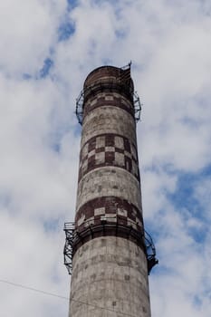 a huge industrial pipe pollutes the atmosphere with chemical emissions.