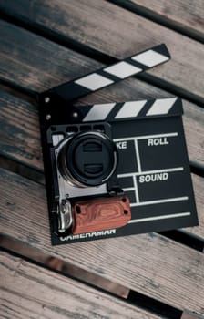 Digital camera and movie clapper for photos and videos on wood background