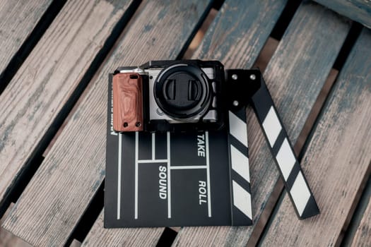 Vintage image - camera and movie clapper on wooden background