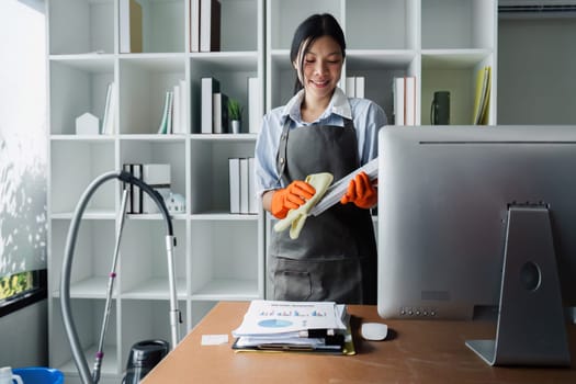 Female housekeeper smile and wearing glove, preparing to clean office.