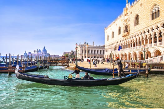 Venice, Italy, February 14 2024 - Duke palace waterfront in Venice gondolas on Valentines day view. Famous tourist spot in Italy, visited by many tourists.