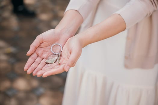 Woman landlord holds keys symbolizing a new home. Represents success tenant security and property ownership. Real estate achievement displayed in close-up. Give me the keys