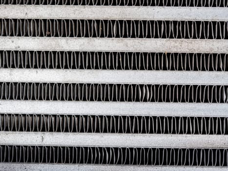 The metal grill of a car radiator is old and has scale marks