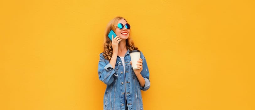 Modern happy young woman calling on mobile phone in denim jacket on yellow studio background