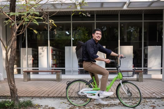 Young Asian businessman Go to work by cycling to reduce air pollution and stay healthy..