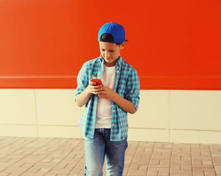 Portrait of teenager boy with smartphone using gadget on colorful background