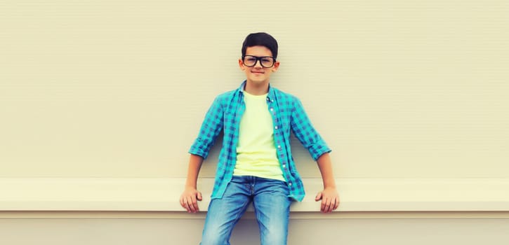 Happy smiling teenager boy in eyeglasses, casual shirt posing on white background