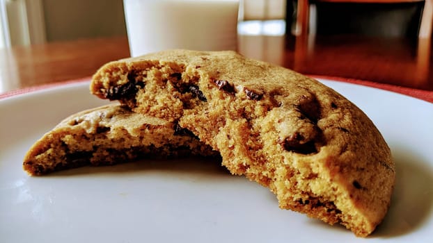 Freshly Baked Chocolate Chip Cookie on White Plate with Glass of Milk in Homely Kitchen, Fort Wayne, Indiana, 2021