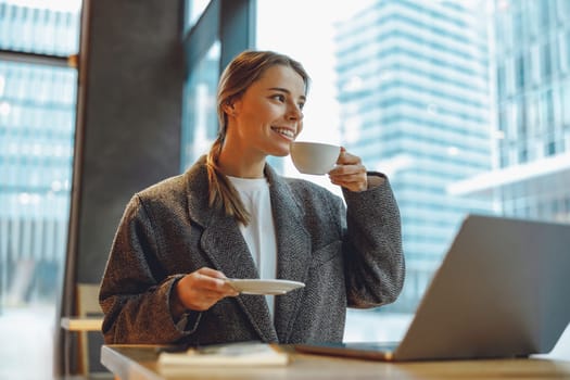 Stylish woman manager freelancer working on laptop while sitting in cozy cafe. High quality photo