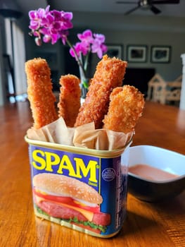 Creative comfort food presentation with deep-fried mozzarella sticks served in a SPAM tin, set in a cozy home dining setting in Fort Wayne, Indiana, 2022.