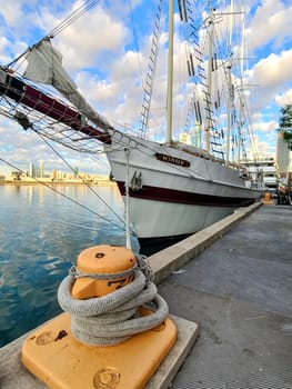 Majestic tall ship Windy moored at Chicago's Navy Pier, juxtaposing historical maritime charm against a modern city skyline, under the warm glow of a late afternoon sun in 2022.