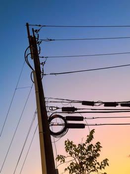 Sunrise illuminating a utility pole laden with electrical equipment in Bloomington, Indiana, symbolizing technology intersecting with nature