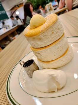 Fluffy Japanese-style souffle pancakes served at a bustling San Francisco restaurant in 2023, epitomizing modern gourmet comfort food.