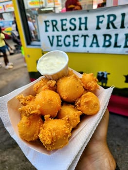 Golden fried cheese balls served at a lively outdoor food market in Fort Wayne, Indiana, 2023