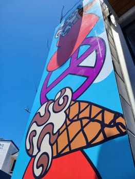 Vibrant mural of a playful ice cream cone on a restaurant in San Francisco, symbolizing urban renewal and creativity, 2023