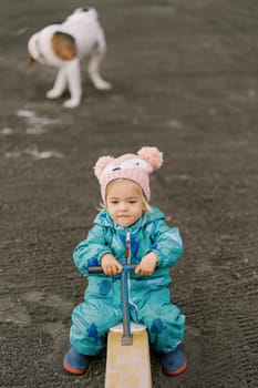 Little girl swinging on a swing-balancer biting her lip. High quality photo