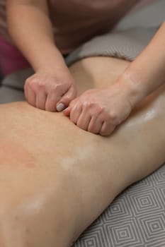 Woman having a therapeutic back massage. Vertical photo