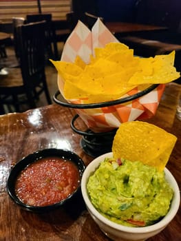 Fresh Mexican appetizer of tortilla chips, guacamole and salsa in a casual dining setting in Ann Arbor, Michigan