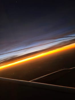 Airplane wing over the Bahamas at sunset, showcasing a vibrant horizon and serene clouds.