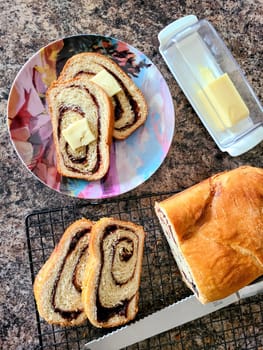 Freshly baked swirl bread with butter, cooling on a kitchen countertop in a cozy home setting in Fort Wayne, Indiana, 2021.