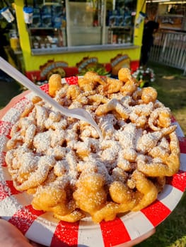 Sugary funnel cake at a vibrant outdoor festival in Fort Wayne, Indiana, 2023 - symbolizing indulgent summer treats and cheerful street food culture.