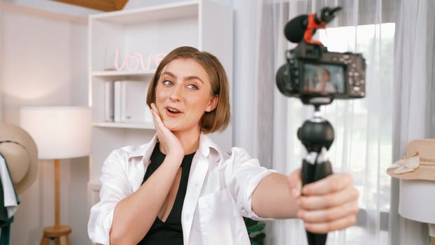 Woman influencer shoot live streaming vlog video review clothes prim social media or blog. Happy young girl with apparel studio lighting for marketing recording session broadcasting online.