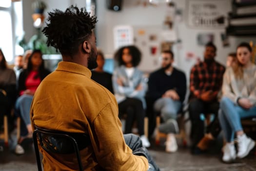 A man attentively listens at a community workshop, focused on mental health awareness. The diverse audience reflects engagement and the importance of the topic