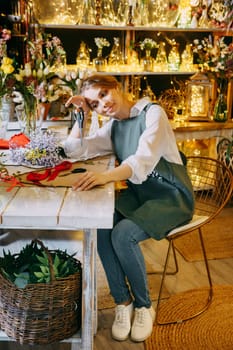 A woman in her florist shop collects bouquets of flowers. The concept of a small business. Bouquets of tulips for the holiday on March 8