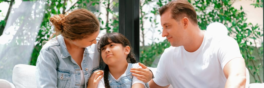 Parents comforting their daughter with loving hug, helping her feel secure and protected from fear, rest her head on shoulder. Happy family love and child care support concept. Panorama Synchronos