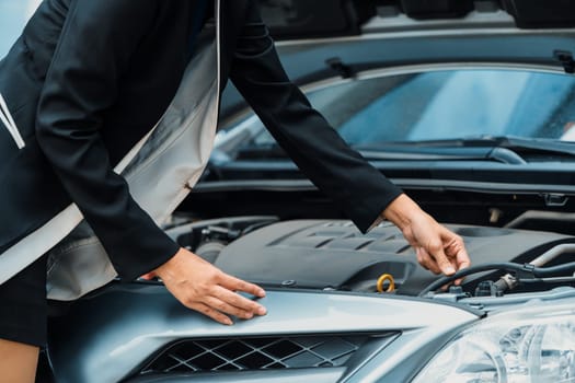 A business woman whose car breakdown try to fix the car by herself without help. uds