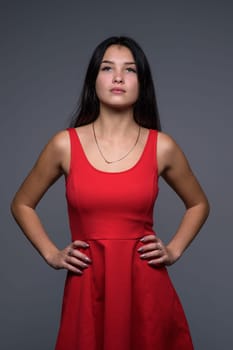 Studio portrait of a young beautiful girl in a red dress 2