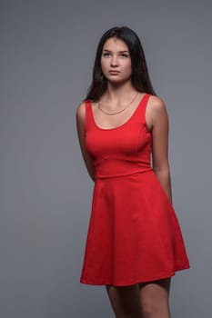 Studio portrait of a young beautiful girl in a red dress