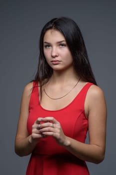 Studio portrait of a young beautiful girl in a red dress 1