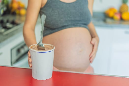 Happy pregnant young woman eating ice cream.