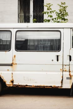 Old rusty white van. Old, rusty, damaged and abandoned mini bus