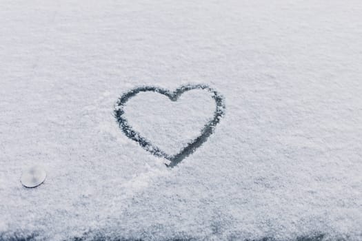 Heart symbol drawn on the snow, on winter day. Romance. Valentine's Day.