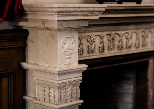Classic vintage fireplace with ornamental elements in old mansion house
