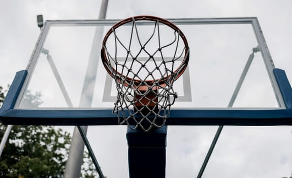 Basketball Shield with a ring in the backyard. Home yard with basketball court.