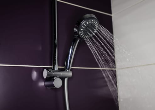 Steel shower head spraying drops down in bathroom. running water of shower faucet