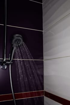 Fresh shower behind wet with water drops splashing. Water running from shower head.