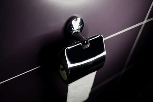 roll of soft toilet paper neatly hanging on a modern chrome holder