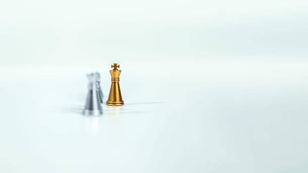 Golden king chess on the board in front of silver chess pieces on white background with copy space, Leadership, fighter, business leadership, competition, confrontation, and business strategy concept.