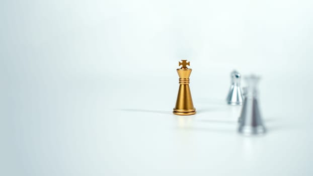 Golden king chess on the board in front of silver chess pieces on white background with copy space, Leadership, fighter, business leadership, competition, confrontation, and business strategy concept.