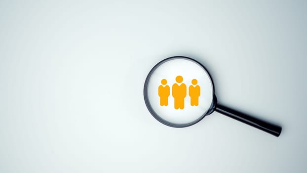 Customer group icons in a magnifying glass placed on a white background represent the selection of business goals, target customers, Marketing plans and strategies, customer-centric strategies.