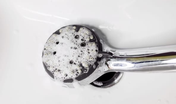cleaning an calcified shower head with foam in domestic bathroom 